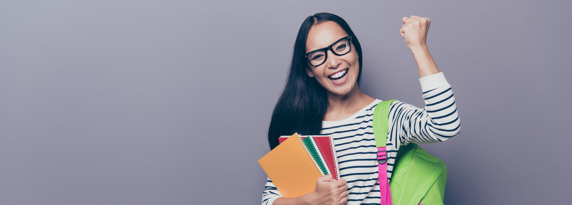 Excited college student holding school supplies