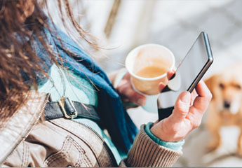 woman with coffee on phone with dog to promote convenient services