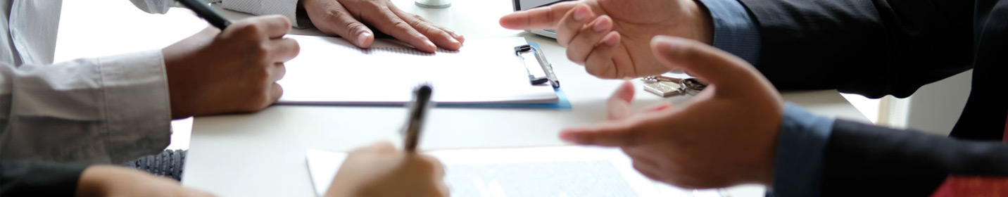 Closeup focused on hands of one person presenting and multiple people taking notes