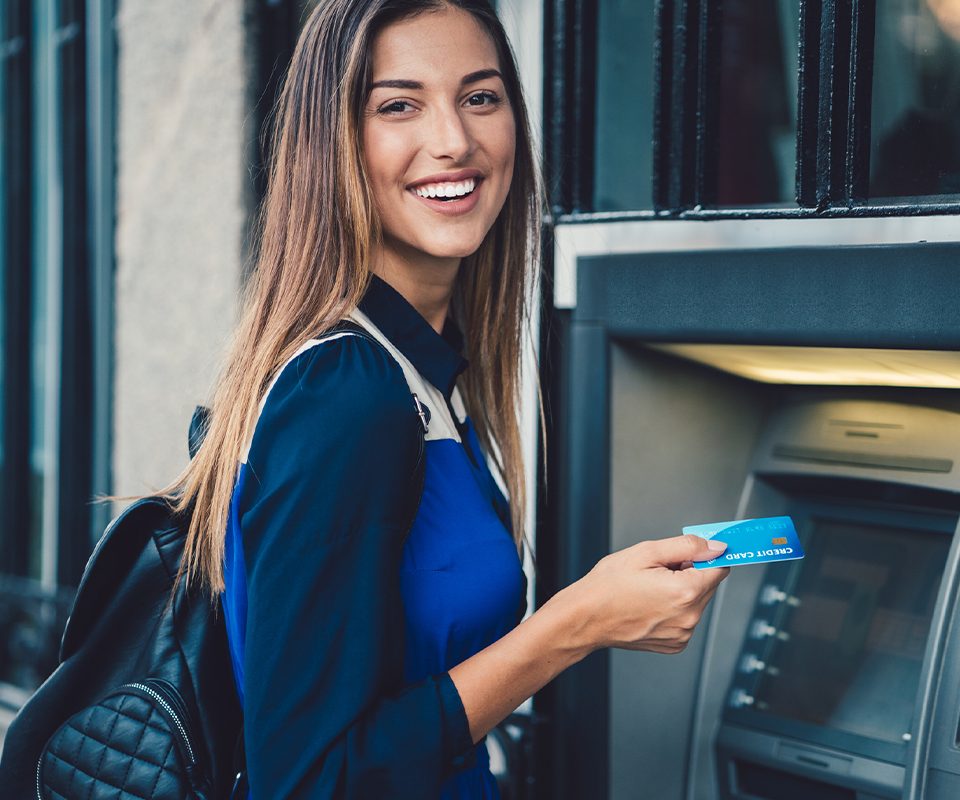 Smiling woman using her card at an ATM