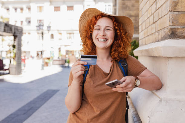 Happy female traveler with a backpack smiling and looking at her phone.