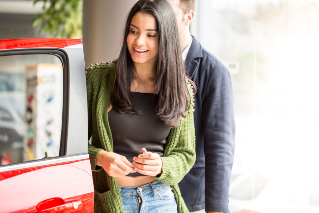 Couple checking a red car in showroom